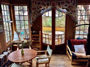 sala de estar con mesa y algunas ventanas en La Casa entre los Árboles en el Valle de Elqui Montegrande, en Paihuano