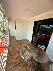 馬拉戈日的住宿－Casa - Peroba，带阳台的客房内的桌椅