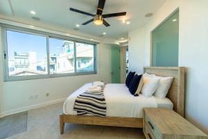 a bedroom with a bed and a ceiling fan at Ocean view, two-level condo with stunning view, decks, fast WiFi & fireplace in San Diego