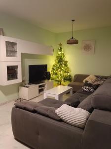 ein Wohnzimmer mit einem Weihnachtsbaum und einer Couch in der Unterkunft Ático Mirabal in Mairena del Aljarafe