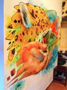 un dipinto di una persona che tiene in mano un giaguaro di Punto Sagrado a Ollantaytambo