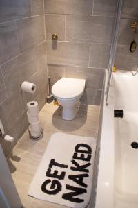 a bathroom with a toilet and a rug on the floor at SW Stay - Stylish One Bedroom with patio in London