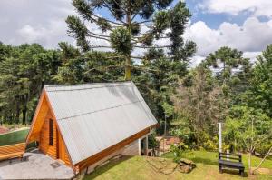 una pequeña casa de madera con techo de metal en Casa Papai Noel, en Campos do Jordão