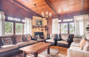 sala de estar con sofás, mesa y chimenea en Casa Papai Noel, en Campos do Jordão