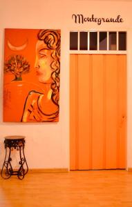 an orange door with a picture of a woman on the wall at Hostal arbol cafe caicedonia in Caicedonia