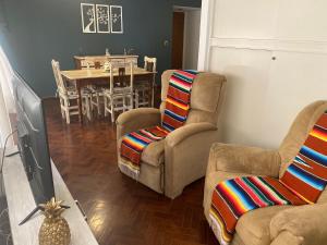 a living room with two chairs and a table at Alquiler cálido departamento en el corazon mendocino in Mendoza