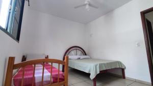 ein kleines Schlafzimmer mit einem Bett und einem Stuhl in der Unterkunft Apê Aconchego I in Águas de São Pedro