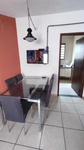 a dining room with a glass table and chairs at Apê Aconchego I in Águas de São Pedro