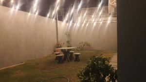 a patio with a table and benches and lights at Mecejana Home in Boa Vista