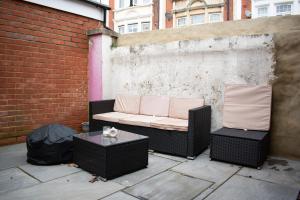 a couch sitting on a patio with a table at SW Stay - Stylish One Bedroom with patio in London