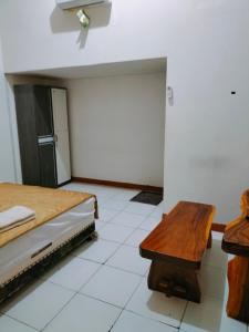 1 dormitorio con 1 cama, mesa y nevera en Mozza guest house en Klaten
