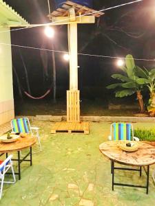 a patio with two tables and chairs and a pole at Aquiri Hostel in Rio Branco