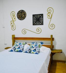 1 dormitorio con 1 cama con almohadas azules y blancas en Hostal arbol cafe caicedonia, en Caicedonia