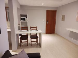 uma sala de estar com uma mesa e duas cadeiras em Sol Marina Loft em Mangaratiba