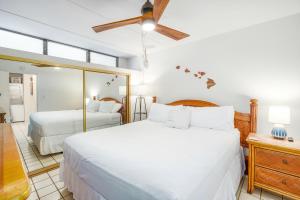 een slaapkamer met twee bedden en een spiegel bij Kihei Akahi C-608 - Stunning Ocean Views, AC! in Wailea +53 foto's