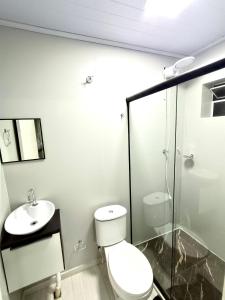 a bathroom with a toilet and a sink at Loft Lux 4 in Chapecó