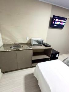 a bathroom with a sink and a microwave at Loft Lux 4 in Chapecó