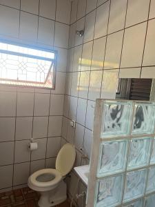 a bathroom with a toilet and a sink and a window at Hotel Ceres - suíte Araras Azuis - 11 in Cuiabá