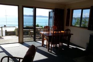 a dining room with a table and a view of the ocean at Beachsider unit 2 in Whitianga