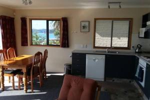 a kitchen and dining room with a table and chairs at Beachsider unit 2 in Whitianga