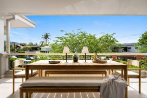a dining room with a table and chairs on a patio at Designer Retreat Meets Vibrant Beachside Living in Palm Beach
