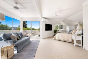 a living room with a bed and a couch at Designer Retreat Meets Vibrant Beachside Living in Palm Beach