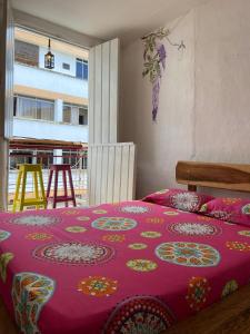 a bedroom with a bed with a purple blanket at Hostal arbol cafe caicedonia in Caicedonia