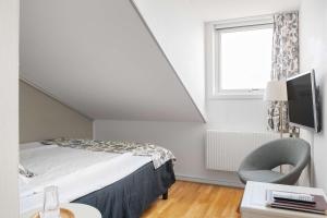 a bedroom with a bed and a chair and a window at Hotel Svea - Sure Hotel Collection by Best Western in Simrishamn