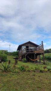 ein großes Holzhaus mit einer großen Terrasse in der Unterkunft Koa Cabana praia do luz in Imbituba