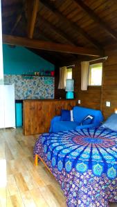 a bedroom with a blue bed and a blue couch at Koa Cabana praia do luz in Imbituba