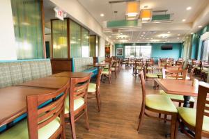 comedor con mesas y sillas de madera en Drury Inn & Suites St. Louis-Southwest, en Peerless Park