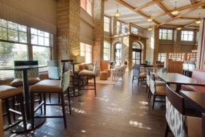 a restaurant with tables and chairs in a room with windows at Drury Inn & Suites Amarillo in Amarillo