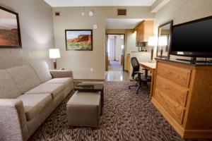 una sala de estar con sofá y escritorio en una habitación de hotel en Drury Inn & Suites Amarillo, en Amarillo