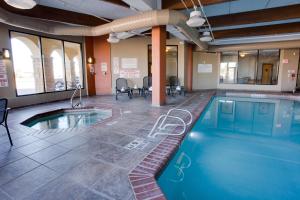 - une piscine dans une pièce avec des chaises et des tables dans l'établissement Drury Inn & Suites Amarillo, à Amarillo