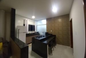 uma cozinha com um balcão preto e um frigorífico branco em Apartamento para até 4 pessoas em Garanhuns-PE em Garanhuns