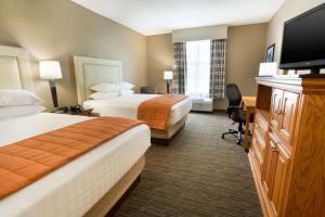 a hotel room with two beds and a flat screen tv at Drury Inn & Suites Lafayette LA in Lafayette