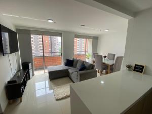 a living room with a couch and a table at Hermoso, moderno y confortable apartamento. in Bello