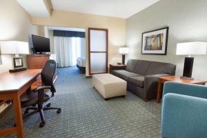 Habitación de hotel con sofá y escritorio en Drury Inn & Suites Grand Rapids, en Cascade