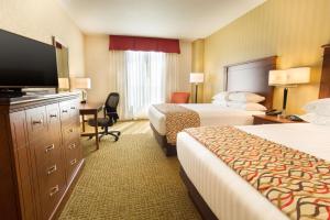 a hotel room with two beds and a flat screen tv at Drury Inn and Suites Denver Central Park in Denver