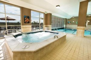 uma grande piscina com uma banheira de hidromassagem num quarto de hotel em Drury Inn and Suites Denver Central Park em Denver