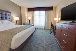 a hotel room with a bed and a flat screen tv at Drury Plaza Hotel St. Louis St. Charles in St. Charles +29 photos