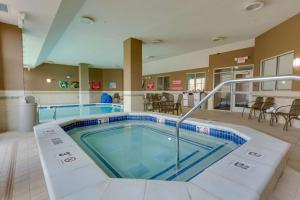 a pool in the middle of a room with tables and chairs at Drury Plaza Hotel St. Louis St. Charles in St. Charles