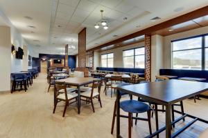 - une salle à manger avec des tables, des chaises et des fenêtres dans l'établissement Drury Inn & Suites Lafayette IN, à Lafayette