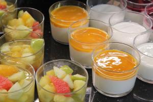 a group of glass cups filled with fruit and milk at Best Western Plus Le Conquerant Rouen Nord in Bois-Guillaume