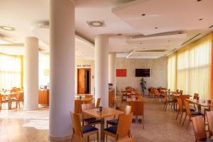 ein Restaurant mit Tischen, Stühlen und einem Fernseher in der Unterkunft Best Western Hotel Fiera Verona in Verona