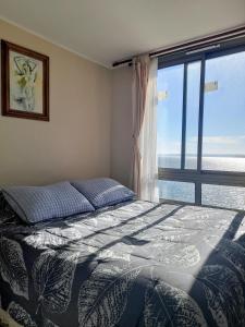 トメにあるDepartamento COSTANERA Playa Bellavista Tomeのベッドルーム1室(ベッド1台、大きな窓付)