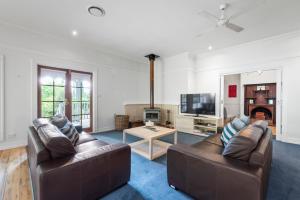 a living room with two leather couches and a tv at Magical Lucindale - Gorgeous 4 Bedroom House in Lucaston