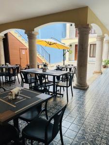 an outdoor patio with tables and chairs and an umbrella at Casona 1530 in Tequila