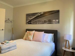1 dormitorio con 1 cama con una foto en la pared en Falls Cottage Whitfield en Whitfield