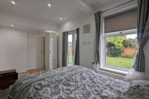 1 dormitorio con cama y ventana grande en Cozy Barnhill Annex en Mánchester